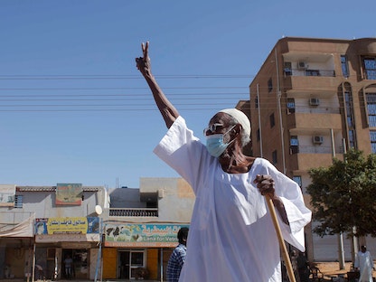 رجل سوداني مسن يرفع علامة النصر بينما يحتشد المتظاهرون للمطالبة بعودة الحكم المدني في العاصمة الخرطوم - 21 نوفمبر 2021 - AFP
