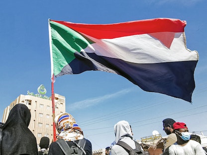 متظاهرون يحملون علم السودان في العاصمة الخرطوم - 4 يناير 2022 - AFP