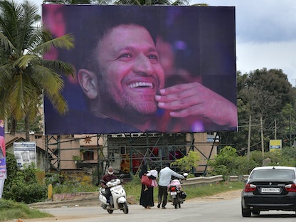 ملصق للنجم السينمائي الهندي الراحل بونيث راجكومار، تم نشره للإشادة بوفاته الأخيرة إثر أزمة قلبية، في بنغالور، الهند. 1 نوفمبر 2021  - AFP