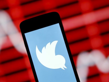 شعار "تويتر" على هاتف ذكي أمام رسم بياني للأسهم في وسط مدينة زينيكا بالبوسنة والهرسك - 29 أبريل 2015 - REUTERS