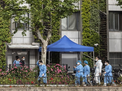أفراد من فرق المسح الطبية تجول شوارع شنغهاي خلال إغلاق كورونا - Bloomberg
