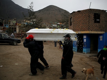 عمال في بيرو يحملون نعشاً لمتوفى جراء كورونا في إحدى مقابر العاصمة ليما. 18 يونيو 2020 - REUTERS