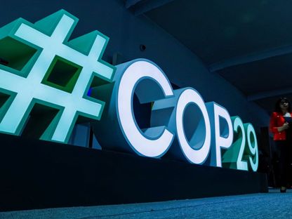 امرأة تمر بجانب لافتة COP29 خلال مؤتمر الأمم المتحدة لتغير المناخ COP29 في باكو عاصمة أذربيجان. 11 نوفمبر 2024 - REUTERS