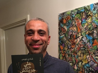 الروائي المصري شادي لويس يحمل روايته "على خط جرينيتش" - facebook/@shady.l.botros
