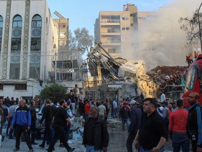 أشخاص يتجمعون بالقرب من موقع غارة إسرائيلية استهدفت قنصلية إيران في العاصمة السورية دمشق. 1 أبريل 2024 - Reuters