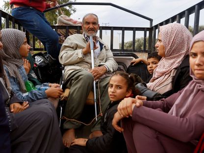 فلسطينيون فارون من شمال غزة يركبون في الجزء الخلفي من شاحنة أثناء تحركهم جنوباً وسط حرب إسرائيل على قطاع غزة. 12 نوفمبر 2023. - Reuters