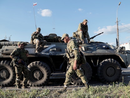 جنود من القوات الموالية لروسيا ينتظرون قبل إجلاء الجنود الأوكرانيين الجرحى من مصنع "آزوف ستال" بمدينة ماريوبل الأوكرانية. 16 مايو 2022 - REUTERS