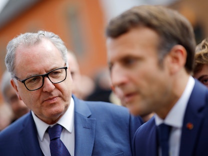 رئيس الجمعية الوطنية السابق ريشار فيران بجانب الرئيس الفرنسي إيمانويل ماكرون في باريس- 5 أبريل 2022 - REUTERS