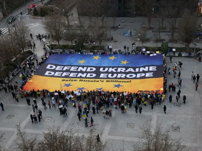 نشطاء أوكرانيون في بروكسل يحملون لافتة تحض القادة الأوروبيين على مصادرة الأصول الروسية المجمدة لتمويل أوكرانيا. 5 مارس 2025 - REUTERS