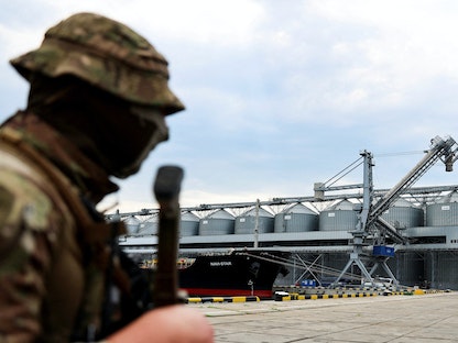 جندي أوكراني يقف أمام صوامع تخزين الحبوب في ميناء أوديسا الأوكراني على البحر الأسود. 29 يوليو 2022 - REUTERS
