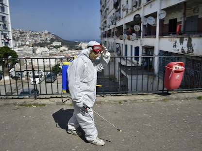 عمال بلدية مدينة الجزائر خلال عملية تعقيم شوارع العاصمة لمكافحة فيروس كورونا. 9 أبريل 2020 - AFP