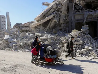فلسطينيات يدفعن عربة محملة بالأمتعة عبر أنقاض مباني مدمرة في مدينة غزة وسط وقف إطلاق النار بين إسرائيل وحماس. 15 أكتوبر 2025 - رويترز