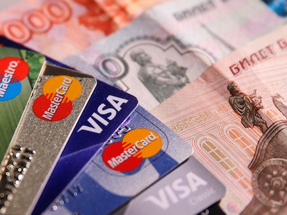  بطاقات "فيزا" و"ماستركارد" و"مايسترو" أمام أوراق نقدية من عملة الروبل الروسية  - REUTERS