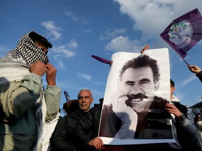 متظاهر يحمل صورة الزعيم الكردي المسجون عبد الله أوجلان خلال تجمع في ديار بكر بتركيا. 27 فبراير 2025 - Reuters