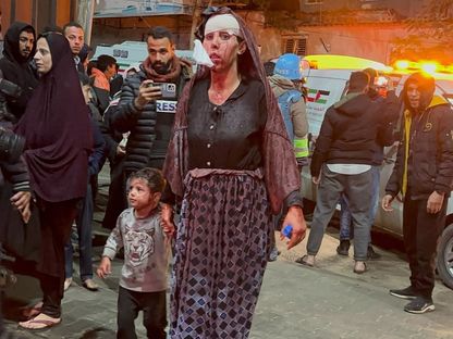 امرأة فلسطينية مصابة مع ابنها بعد غارات إسرائيلية على مدينة رفح، يدخلان إلى المستشفى الكويتي جنوب غزة. 12 فبراير 2024 - AFP