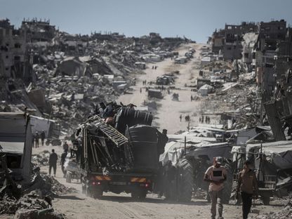 نازحون فلسطينيون في مخيم جباليا شمال غزة يمشون وسط الدمار الذي خلفه الجيش الإسرائيلي. 21 مايو 2025 - Bloomberg