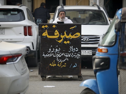 صراف للعملات في الشارع، بغداد 27 ديسمبر 2022 - AFP