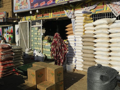 سودانية تمشي أمام محل لبيع المواد الغذائية بالعاصمة الخرطوم. 19 يناير 2023 - AFP