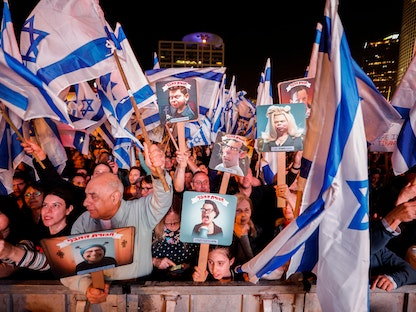متظاهرون إسرائيليون يحملون أعلاماً ولافتات في تل أبيب احتجاجاً على التعديلات القضائية التي تسعى حكومة نتنياهو لإقرارها. 4 مارس 2023 - REUTERS