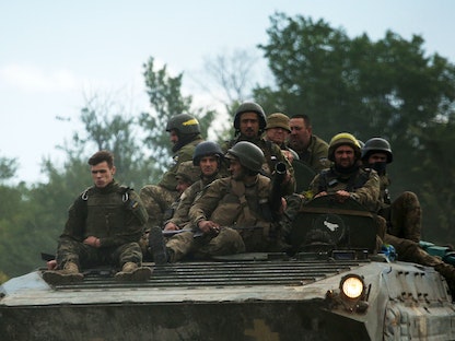 جنود أوكرانيون يركبون ناقلة جنود مدرعة (APC) على طريق منطقة لوغانسك الشرقية، 23 يونيو 2022. - AFP