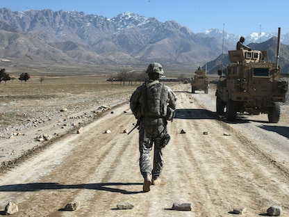 جندي أميركي يسير على امتداد طريق قيد الإنشاء بالقرب من قاعدة باغرام على بعد 60 كيلومتراً من العاصمة الأفغانية كابول - AFP