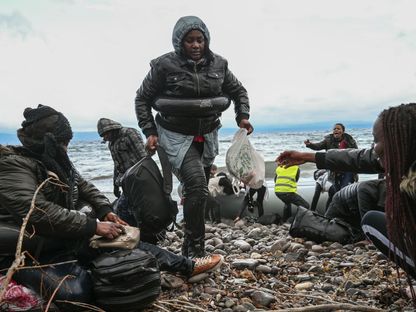 نازحون من غامبيا وجمهورية الكونغو الديموقراطية في جزيرة ليسبوس اليونانية بعد عبورهم البحر بين تركيا واليونان. 29 فبراير 2020. - AFP