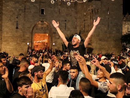 متظاهرون فلسطينيون يحتفلون في ساحة باب العمود بالقدس بعد إزالة الحواجز الإسرائيلية- 25 أبريل 2021 - REUTERS