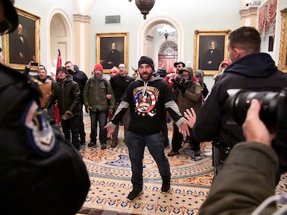 أحد أعضاء حركة "كيو أنون" المؤيد للرئيس السابق دونالد ترمب، خلال اقتحام مبنى الكابيتول - 6 يناير 2020  - REUTERS