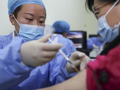 صينية تتلقى جرعة من لقاح سينوفاك المضاد لفيروس كورونا، 1 أبريل 2021 - AFP