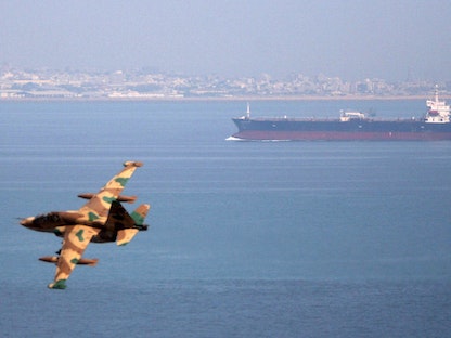 طائرة حربية إيرانية تحلق بالقرب من ناقلة نفط خلال مناورات بحرية في خليج عُمان، 5 أبريل 2006. رويترز / أخبار فارس - REUTERS