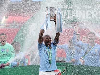 فيرناندينيو يرفع كأس كاراباو ولاعبو مانشستر سيتي يحتفلون باللقب - Pool via REUTERS