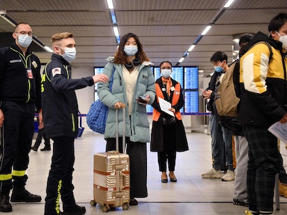 ركاب رحلة قادمة من الصين ينتظرون في طابور للتحقق من وثائق التطعيم الخاصة بفيروس كورونا بعد وصولهم إلى مطار شارل ديجول قرب باريس. 1 يناير 2023 - AFP