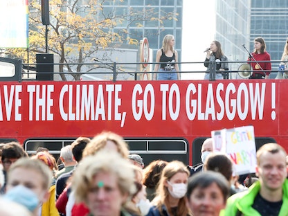 أشخاص يتظاهرون في بروكسل ضد التغير المناخي قبل قمة المناخ (كوب26) نوفمبر المقبل في جلاسكو، 10 أكتوبر 2021 - REUTERS