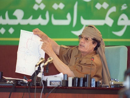 الزعيم الليبي الراحل العقيد معمر القذافي، يعرض خريطة لفلسطين، ليبيا 24 أكتوبر 1995. - AFP
