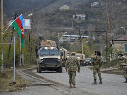 جنود أذربيجانيون يصوّرون شاحنات عسكرية أذربيجانية تدخل بلدة لاتشين - 1 ديسمبر 2020 - AFP