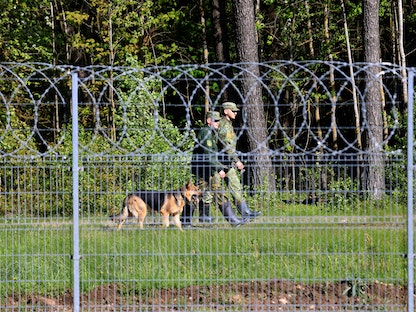 حرس الحدود البيلاروسي في دورية قرب السياج الحدودي بين بيلاروسيا وليتوانيا، 23 مايو 2021 - AFP