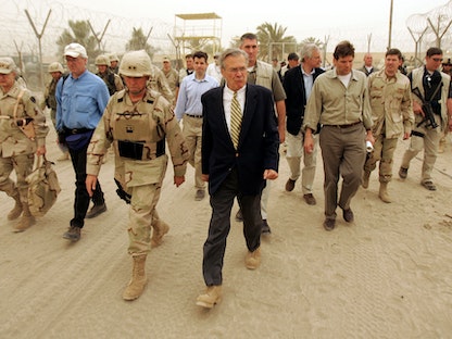وزير الدفاع الأميركي الأسبق دونالد رامسفيلد برفقة مسؤولي في الجيش،  خلال زيارة سجن أبو غريب في العراق. 13 مايو 2004. - AFP