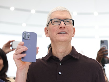 الرئيس التنفيذي لشركة "أبل" تيم كوك يحمل هاتف iPhone 14 Pro في كوبرتينو بكاليفورنيا - 7 سبتمبر 2022  - AFP