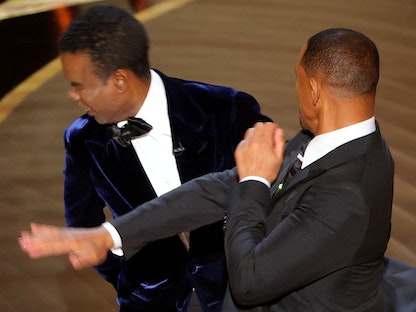 ويل سميث يضرب كريس روك بينما تحدث روك على خشبة المسرح خلال حفل توزيع جوائز الأوسكار رقم 94 في هوليوود، لوس أنجلوس، كاليفورنيا، الولايات المتحدة. 27 مارس 2022 - REUTERS