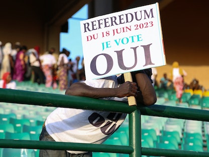 رجل يحمل لافتة أثناء حضوره التجمع الانتخابي الأخير لمجموعة "نعم" للاستفتاء على التعديلات الدستورية في باماكو. 16 يونيو 2023 - REUTERS