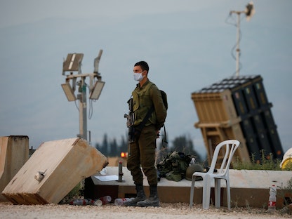 جندي إسرائيلي يقف بجانب نظام القبة الحديدية المضاد للصواريخ بالقرب من الحدود الشمالية مع لبنان. 27 يوليو 2020 - REUTERS
