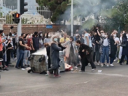 متظاهرون إيرانيون يشعلون النار في مكب نفايات بأحد شوارع العاصمة طهران - AFP