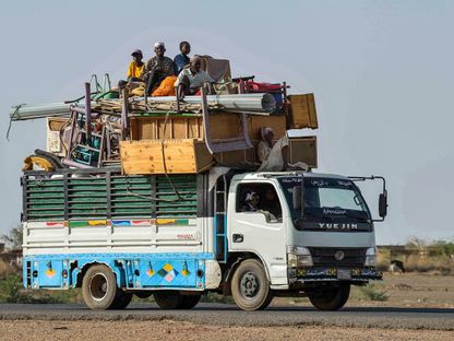 سودانيون على متن شاحنة محملة بالأثاث على الطريق الرابطة بين الخرطوم وواد مدني، السودان. 22 نوفمبر 2023. - AFP