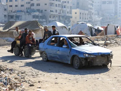 نازحون فلسطينيون في سيارة يجرّون عربة تقلّ أشخصاًا بالقرب من الخيام في ظلّ وقفٍ لإطلاق النار بين إسرائيل وحماس بمدينة غزة. 15 أكتوبر 2025 - Reuters