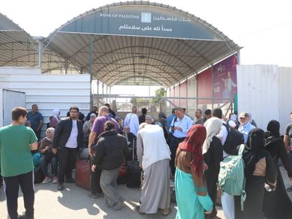 عدد من الفلسطينيين الحاملين لجوازات سفر أجنبية ينتظرون على الجانب الفلسطيني من معبر رفح للعبور إلى مصر مع تصاعد القصف الإسرائيلي على قطاع غزة. 14 أكتوبر 2023 - "الشرق"