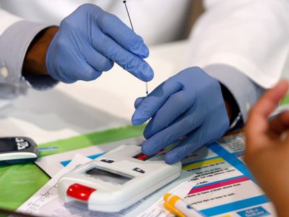 مساعد طبي يستخدم جهازاً يقيس نسبة الكوليسترول خلال فحص مجاني في دالاس، تكساس، 6 أغسطس 2009 - Reuters
