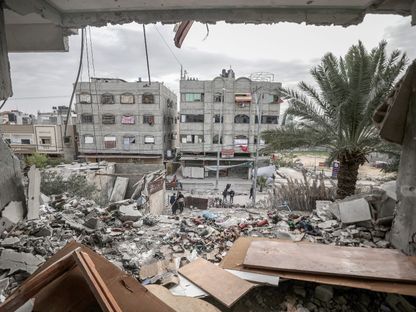 فرق الدفاع المدني في غزة تقوم بعمليات البحث والإنقاذ لأشخاص تحت الأنقاض في أعقاب هجوم إسرائيلي في دير البلح. 23 ديسمبر 2023 - AFP