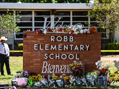 أكاليل الورود أمام شعار مدرسة روب الابتدائية بعد يوم من سقوط 21 ضحية بإطلاق نار، تكساس، الولايات المتحدة، 25 مايو 2022 - AFP