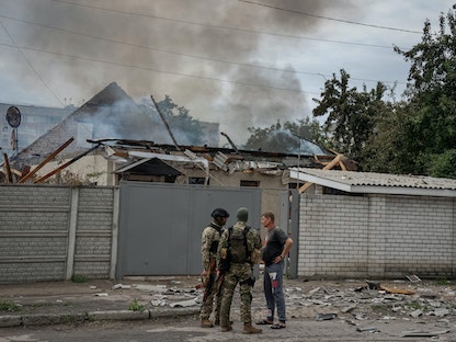 ضباط الشرطة يتحدثون مع أحد السكان المحليين مع استمرار الهجوم الروسي على أوكرانيا في منطقة لوهانسك، أوكرانيا في 2 يونيو 2022. - REUTERS