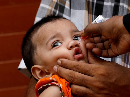 طفلة باكستانية تتلقى لقاح شلل الأطفال في حي منخفض الدخل في كراتشي - REUTERS